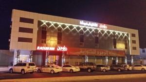 un edificio con coches estacionados fuera de él por la noche en Raoum Inn Khafji Southern, en Al Khafji