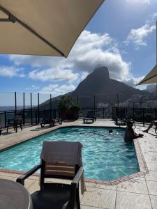 uma piscina com vista para uma montanha em Top Flat Leblon, Piscina Vista Mar, 2 Quadras da Praia, Academia Vista Mar e Arrumação Diária By Tata no Rio de Janeiro