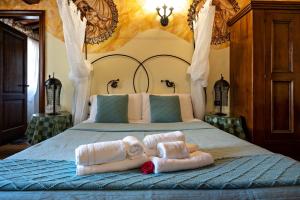 a bedroom with a bed with towels on it at Luxury Corte Di Re Artù in Lucca