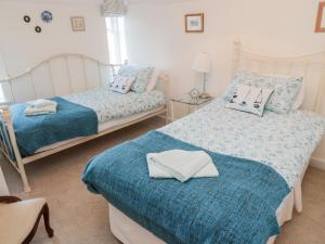 ein Schlafzimmer mit 2 Betten und Handtüchern darauf in der Unterkunft Iona 10 Palace Street East in Berwick-Upon-Tweed