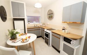 a small kitchen with a small table and a white table at The Old School House in Lytham St Annes