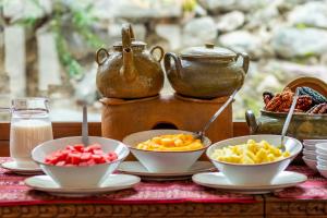 a table with bowls of fruit and a teapot at Del Pilar Ollantaytambo in Ollantaytambo