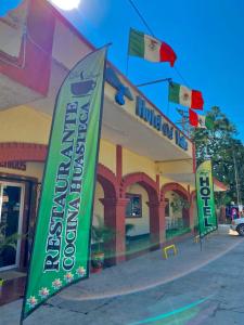 un edificio con banderas delante de una tienda en Hotel Del Valle en El Naranjo