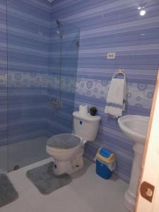 Baño azul con aseo y lavamanos en casa equipada estadia placentera, en Hainamosa
