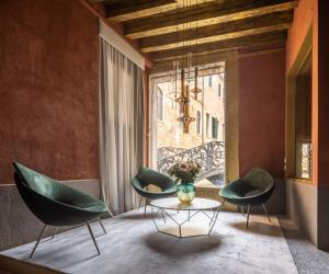 een kamer met 2 stoelen, een tafel en een raam bij Ninfea Luxury Suites in Venetië