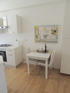 a white kitchen with a white table and chairs at Casa nei pressi del Duomo,Firenze centro storico in Florence