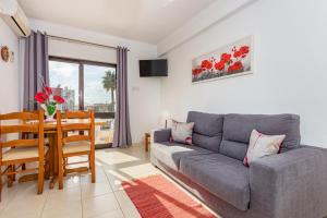 a living room with a couch and a dining room table at Apartamentos Carruna in Albufeira