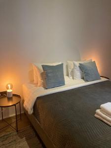 Una cama con almohadas azules y blancas y una mesa. en Luxury Suites Princess en Amberes