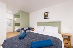 una camera da letto con un grande letto con cuscini blu di Tafarn Yr Heliwr a Nefyn
