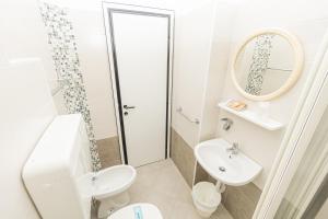 a bathroom with a sink and a toilet and a mirror at Hotel Arlino in Rimini