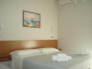 a bedroom with two beds and a picture on the wall at Hotel Amalfi in Rimini
