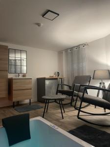 ein Wohnzimmer mit Stühlen und einem Pool in der Unterkunft Magnifique Loft 35m2 Jacuzzi RVB NIGHT 1 in Amiens