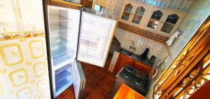 Goodhope 3-Bedroom Vacation Rental في أروشا: ثلاجة مفتوحة بابها مفتوح في مطبخ
