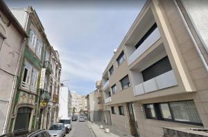 una calle de la ciudad con edificios y coches aparcados en la calle en Residencia Vale Formoso, en Oporto