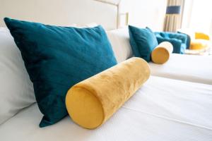 una almohada sentada en una cama junto a una almohada azul en Seth Port Mahón en Mahón