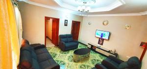 uma sala de estar com um sofá e duas cadeiras em Goodhope 3-Bedroom Vacation Rental em Arusha