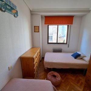 Una pequeña habitación con dos camas y una ventana. en Imperial, 9, en Salamanca