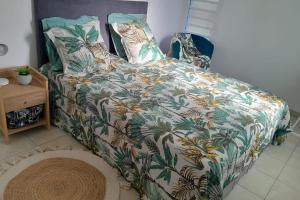 a bedroom with a bed with a colorful comforter at Appartement Seaside in Le Moule