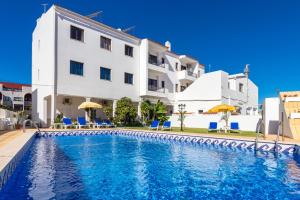 a swimming pool in front of a building at Apartamentos Carruna in Albufeira