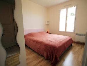 sypialnia z czerwonym łóżkiem i oknem w obiekcie LA PAREE D'EAU A305 - Appartement 5 personnes - Terrasse Jardin Piscine w mieście Notre-Dame-de-Monts +3 zdjęcia