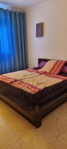 a bed in a bedroom with blue curtains at New Marina Appartement Susi in Hurghada