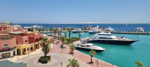 two boats are docked in a marina with buildings at New Marina Appartement Susi in Hurghada