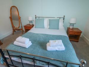 una camera da letto con un letto con asciugamani sopra di Honeysuckle Cottage a Paignton Altre 26 foto