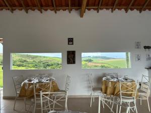 カランカスにあるPousada Sal da Terraのテーブル2台と椅子、窓が備わる客室です。