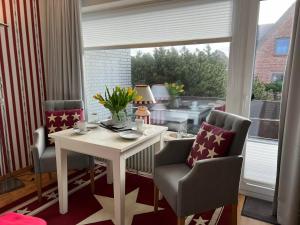 a room with a table and two chairs and a window at Sonnenaufgang in Westerland