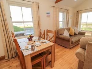 ein Wohnzimmer mit Tisch und Couch in der Unterkunft Home Stead Cottage in Embleton