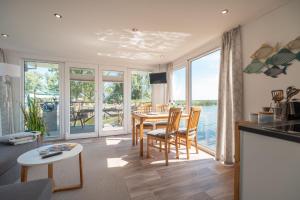 uma cozinha e sala de estar com mesa e cadeiras em Hafenresort Karnin Hausboot Glaukos em Karnin