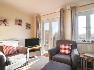 a living room with two chairs and a television at Admirals View in Lyme Regis