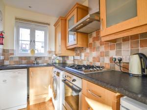 a kitchen with a stove and a dishwasher at Admirals View in Lyme Regis