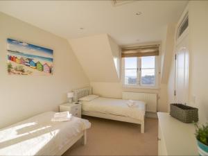 a bedroom with two beds and a window at Admirals View in Lyme Regis