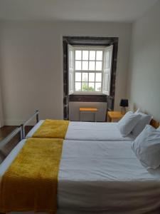 Azores Youth Hostels - Pico في ساو روكي دو بيكو: غرفة نوم بسريرين ونافذة