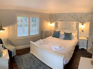 a bedroom with a white bed with two towels on it at Ferryman`s Cottage at The Beetle & Wedge in Moulsford