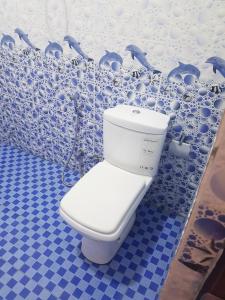 a bathroom with a toilet in a blue and white wall at Kabalana Ocean Blue in Ahangama