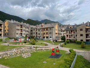 eine Apartmentanlage mit einem Spielplatz im Hof in der Unterkunft Apartamento El Falcar in Villanúa