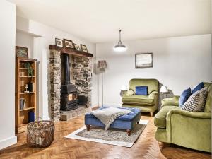 uma sala de estar com duas cadeiras e uma lareira de pedra em Hillcrest House em Ashbourne