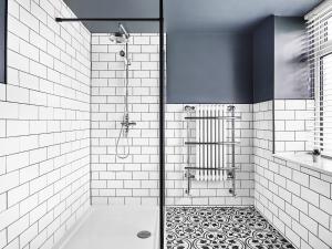 uma casa de banho com um chuveiro com azulejos pretos e brancos em Hillcrest House em Ashbourne
