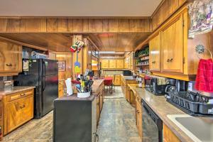 a large kitchen with wooden cabinets and a black refrigerator at Waterfront Home with Boat Dock in Gun Barrel City in Gun Barrel City