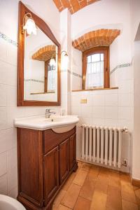 a bathroom with a sink and a mirror and a radiator at Affitti Brevi Toscana - Ospitalità in Campagna in Talamone
