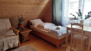 a bedroom with a bed and a table and a window at Chata w chmurach in Gliczarów