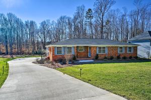a red brick house with a driveway at Ranch-Style Home 7 Mi to Downtown Greensboro! in Greensboro