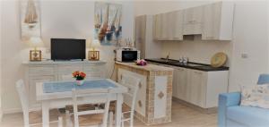 cocina con mesa y cocina pequeña con mesa y sillas en sea ottiolu, en Porto Ottiolu