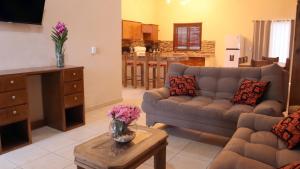 uma sala de estar com um sofá e uma mesa em Hacienda Bella em Cabo San Lucas