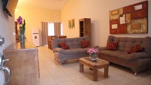 uma sala de estar com dois sofás e uma mesa em Hacienda Bella em Cabo San Lucas
