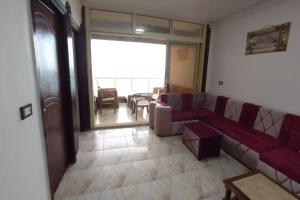 a living room with a red couch and a table at Paradise Beach Alexandria Sea View - Free Wi-Fi - Alex in Alexandria