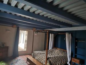 a bedroom with a canopy bed and a blue ceiling at Ferme rénovée avec Piscine in Polignac