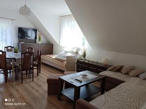 a living room with a couch and a table at Apartament Gajówka z ogrodem na wyłączność, Energylandia 35min in Rzyki